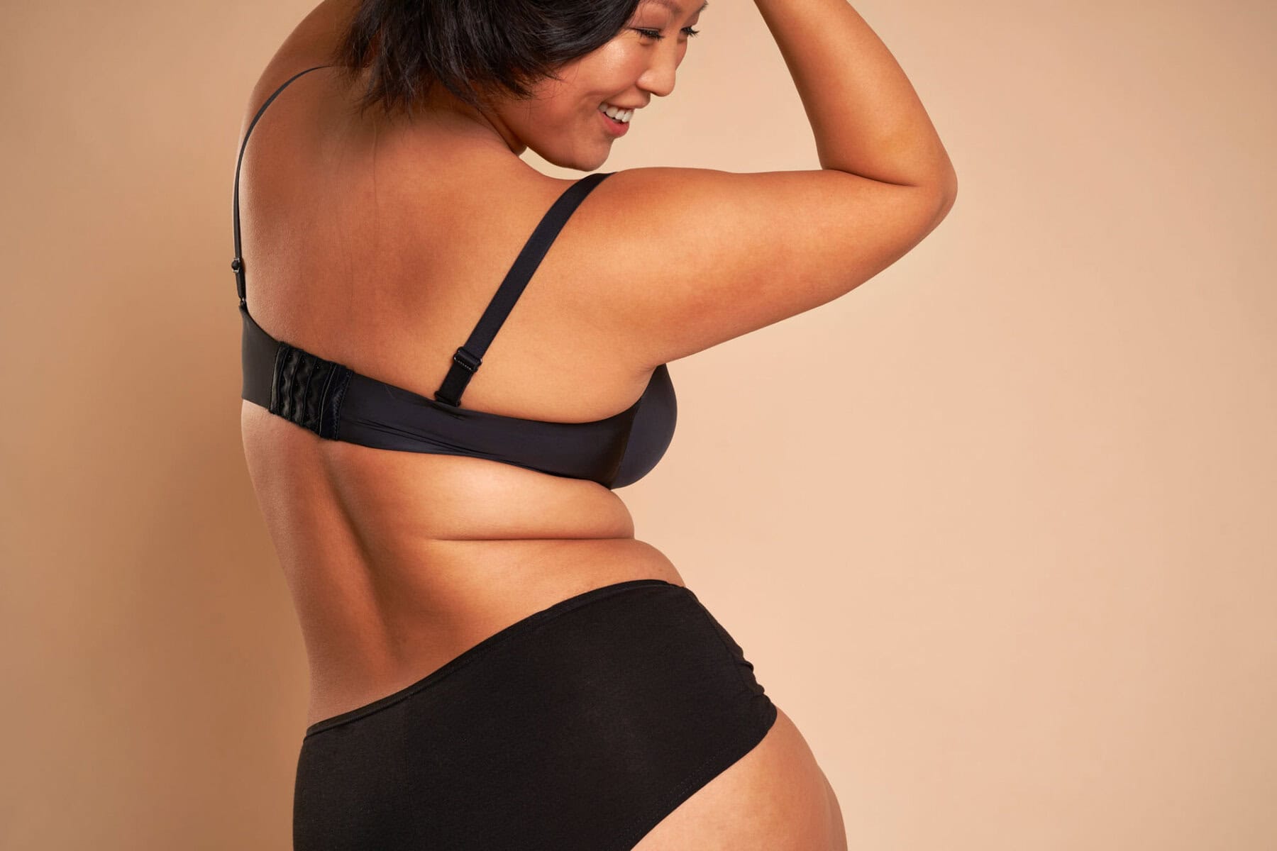 back view of asian woman in underwear turning towards the camera