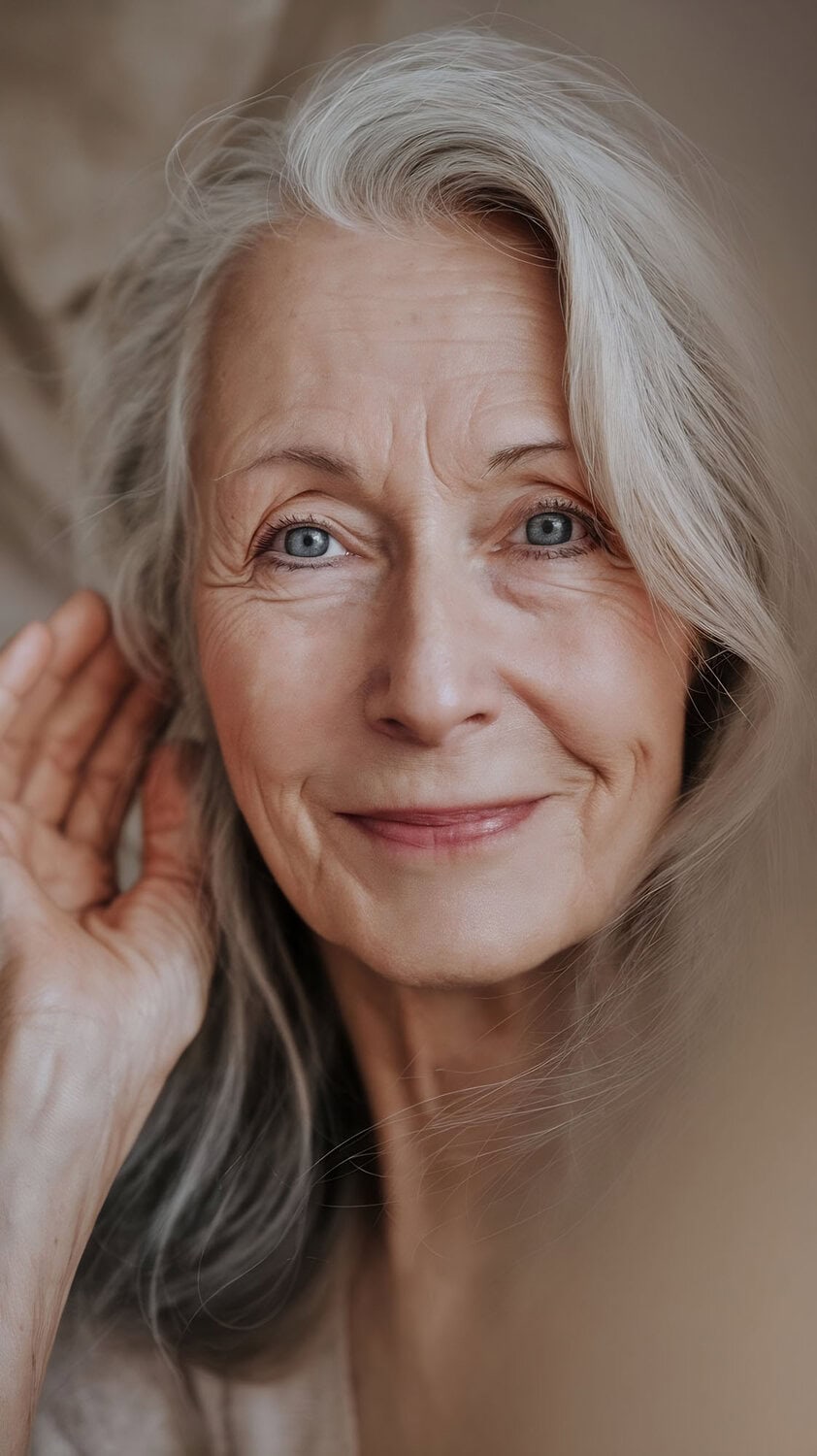 closeup portrait senior woman looking camera touching hair beautiful face smiling