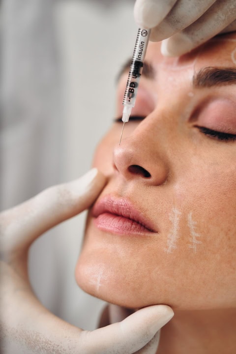 injections into the skin of the face. a woman came to the clinic for facial skin care.