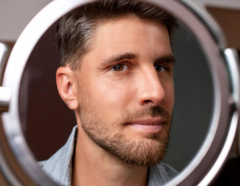 mirror reflecting a person's face, symbolizing reflection, self perception, and introspection.