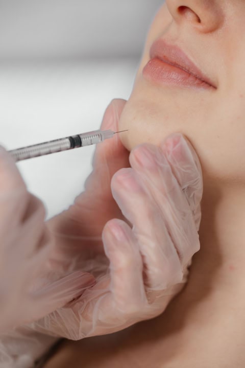 the procedure of a cosmetic injection into the chin.treatment