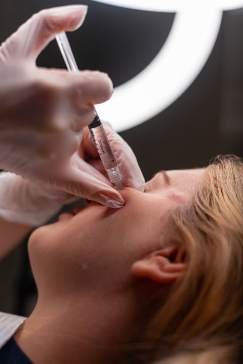 professional cosmetologist woman doing facial skin care and mois