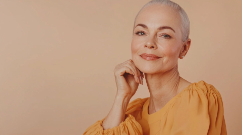 in this captivating close up, a woman with short silver hair showcases her natural beauty and poise. her kind expression and stylish outfit highlight her vibrant personality and confidence